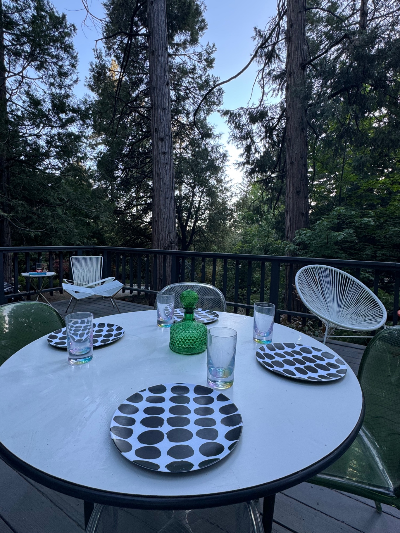 Deck dining table set among the pines at dusk